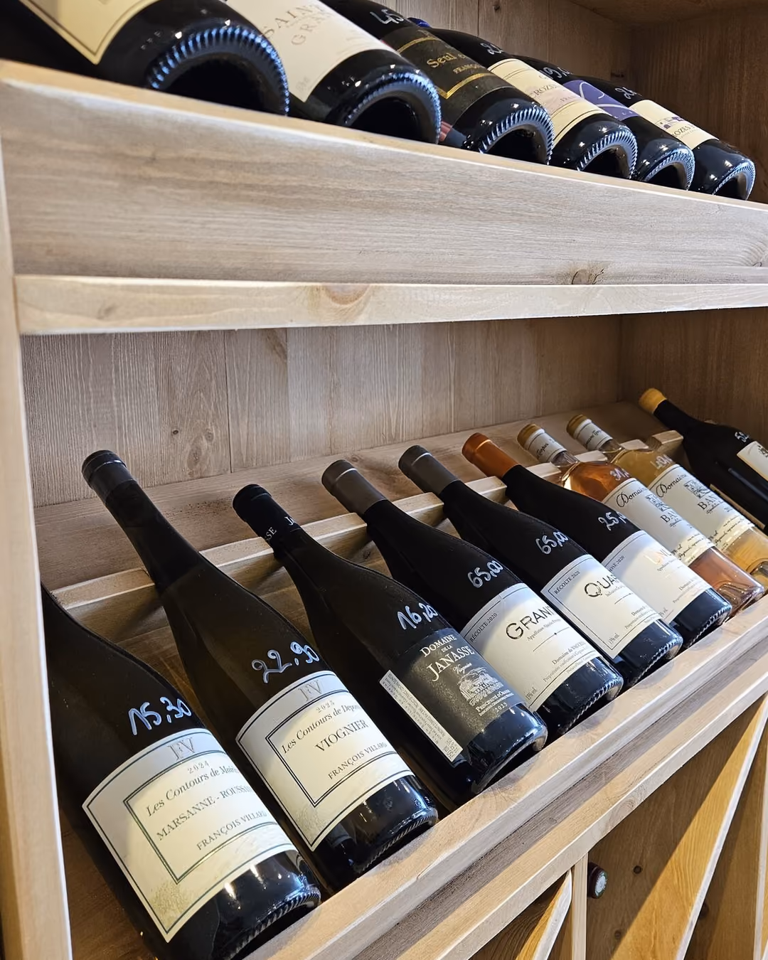 Sélection de bouteilles aux prix écrits à la main chez L'Amicale du Raisin