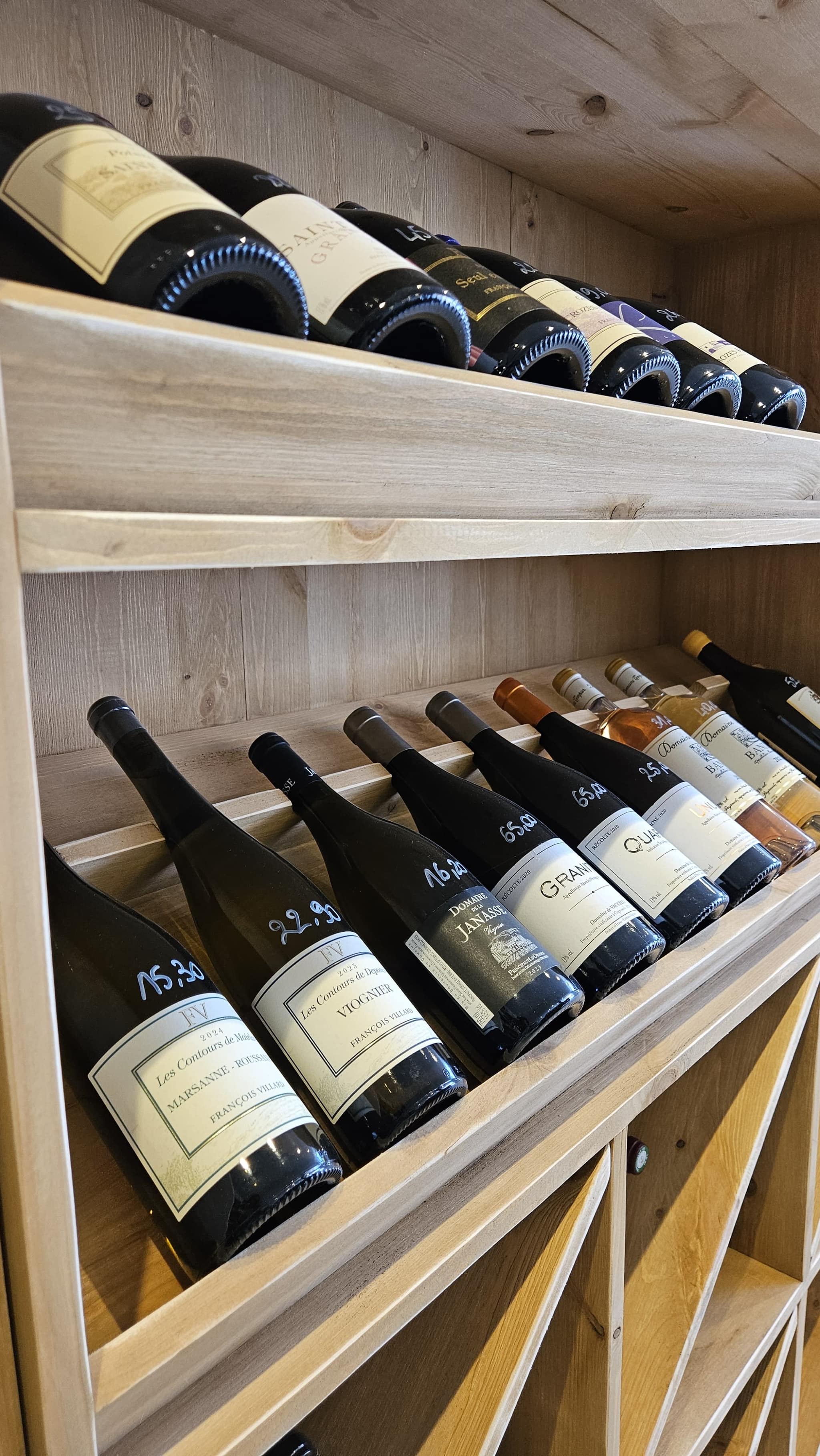 Sélection de bouteilles aux prix écrits à la main chez L'Amicale du Raisin